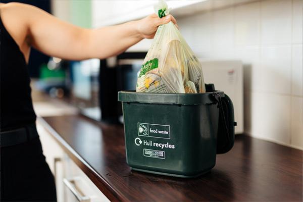 A green caddy being emptied.